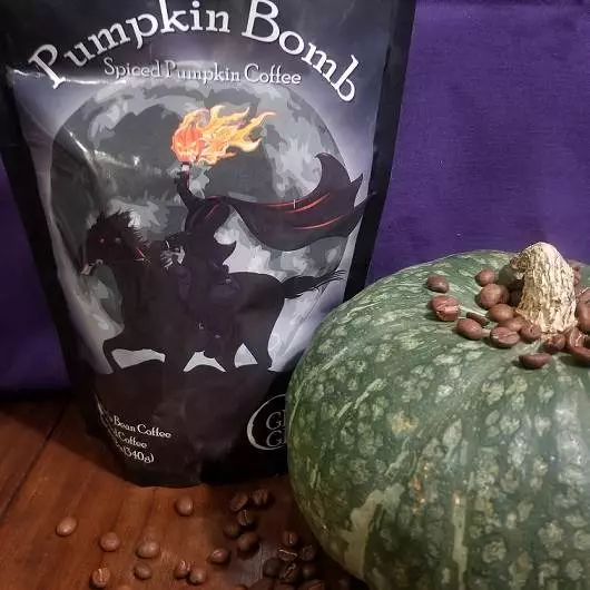 A bag of Geek Grind Coffee Company's Pumpkin Bomb blend and a green Kabocha squash