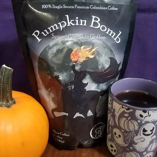 Geek Grind Coffee Company's Pumpkin Bomb blend with a small orange pumpkin and a cup of coffee